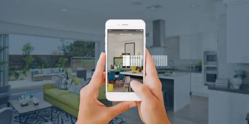 Phone capturing a panorama of a living room and kitchen for a Zillow 3D Home Tour