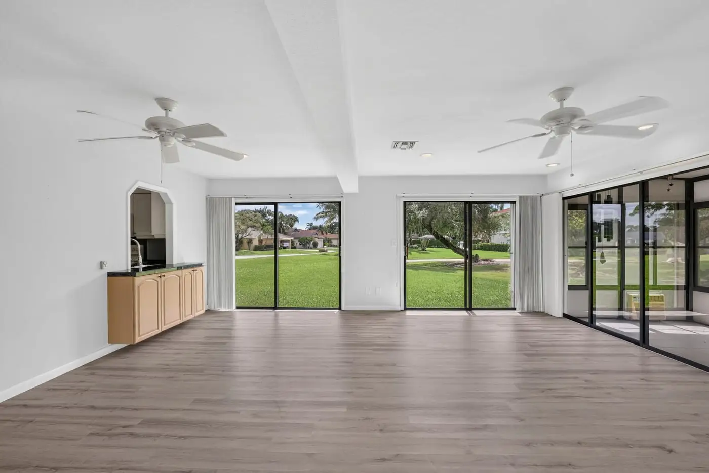 Living room of a South Florida home looking toward the sliding doors, before virtual staging
