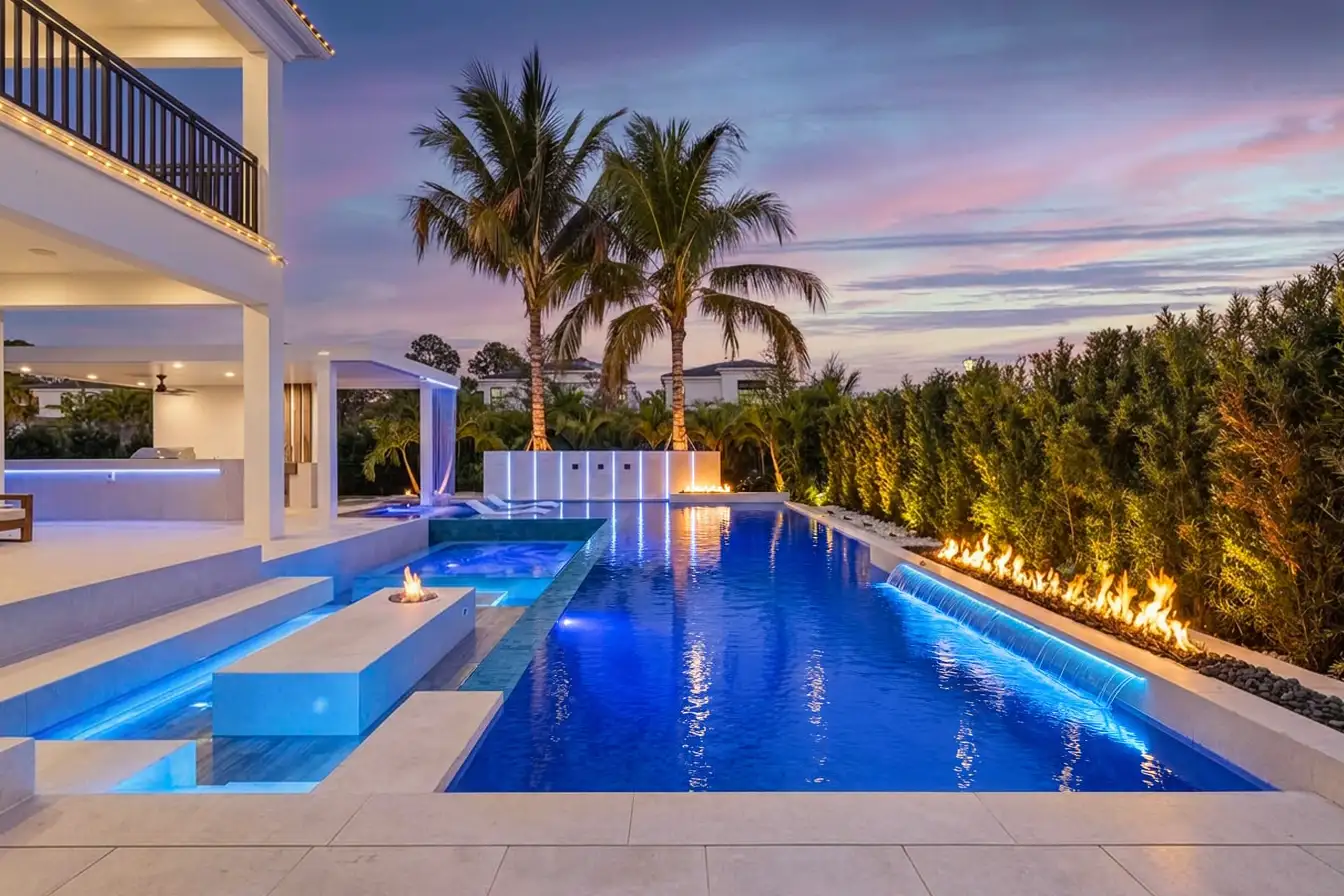 Twilight real estate photo of a South Florida home with a lit pool by Van Kirk Pools